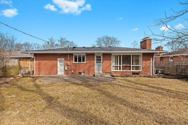 back of house featuring a lawn, entry steps, fence, brick siding, and a patio area