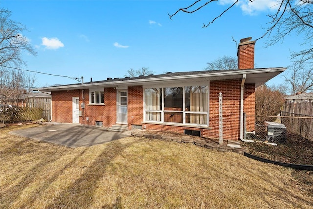 view of front of property with a patio, fence, brick siding, and a chimney