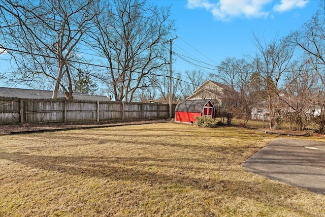 view of yard featuring an outbuilding, a fenced backyard, and a shed