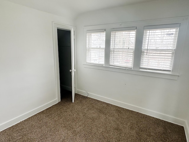 empty room featuring baseboards and carpet flooring