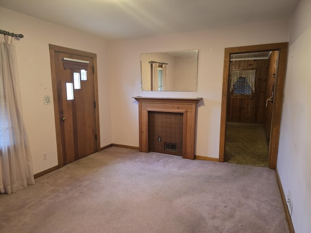 unfurnished living room featuring carpet, visible vents, and baseboards