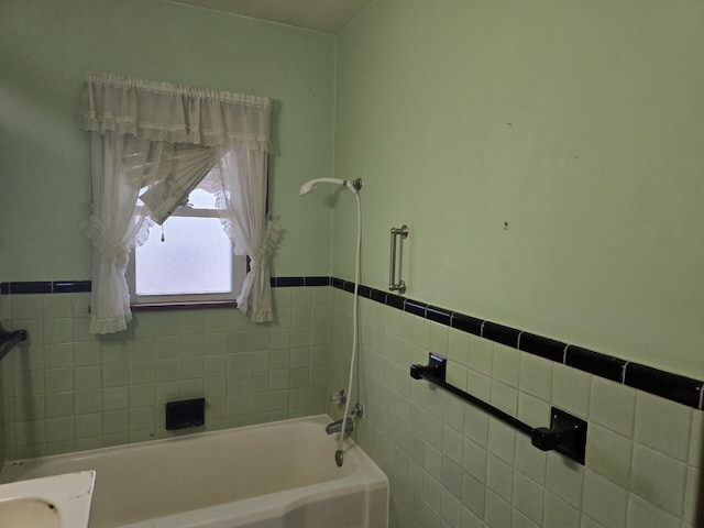 bathroom with wainscoting and tile walls