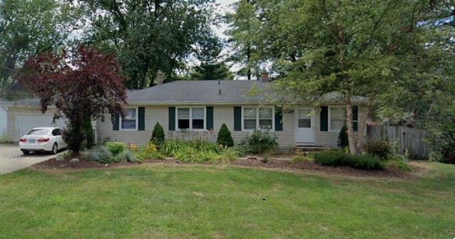 ranch-style home with driveway, an attached garage, fence, and a front yard