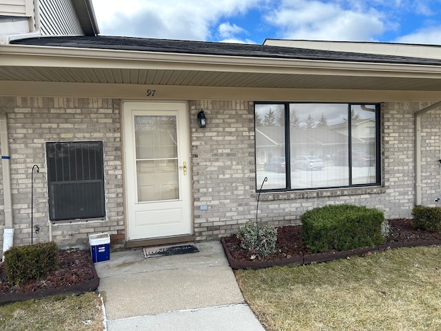 entrance to property featuring brick siding