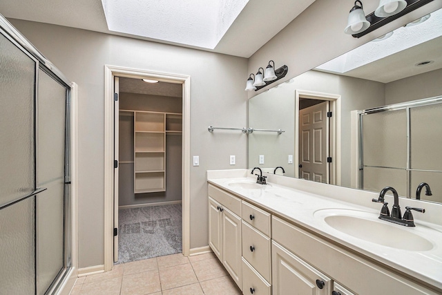 full bathroom featuring a skylight, a sink, and tile patterned floors