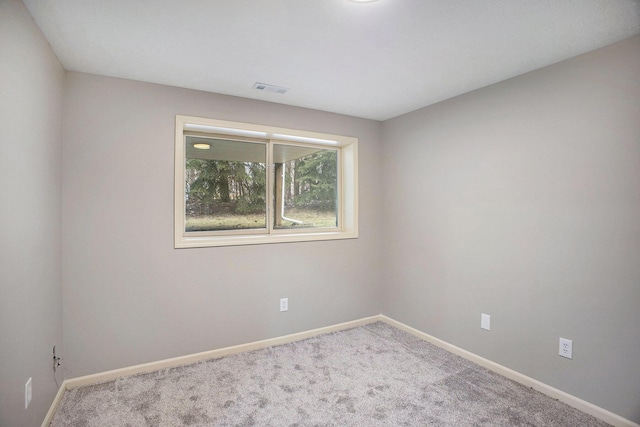 carpeted empty room with visible vents and baseboards