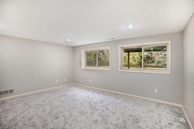 carpeted spare room with baseboards, visible vents, and recessed lighting