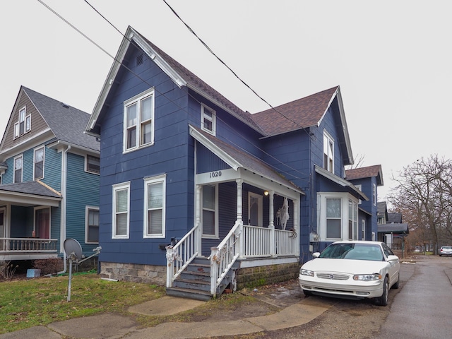 view of front of home with covered porch and roof with shingles