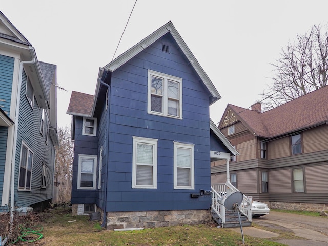 back of property featuring roof with shingles