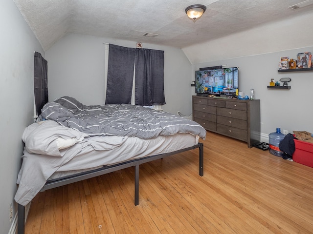 1020 S Park St, Kalamazoo, MI 49001 - bedroom featuring light wood-type flooring, visible vents, vaulted ceiling, and a textured ceiling