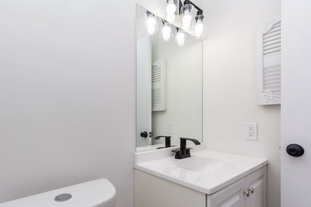 bathroom featuring toilet, a chandelier, and vanity