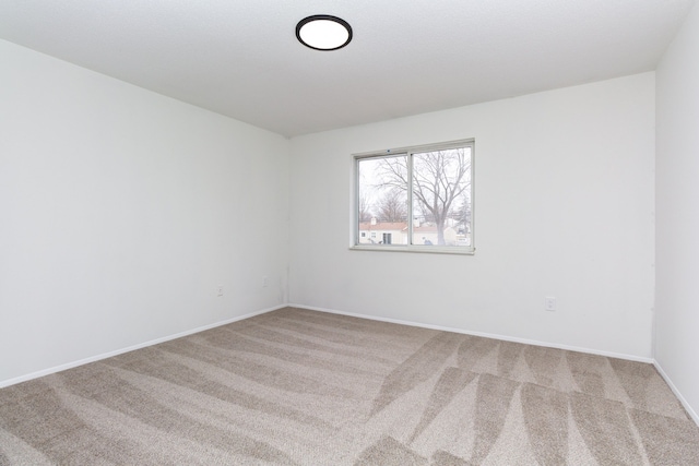 spare room with carpet and baseboards