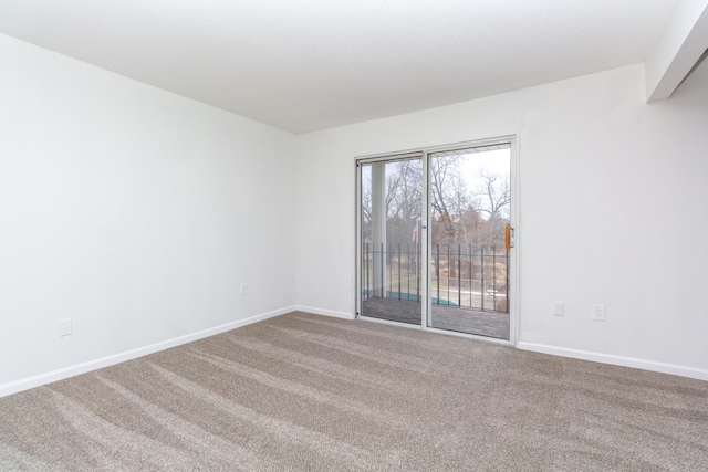 carpeted empty room featuring baseboards