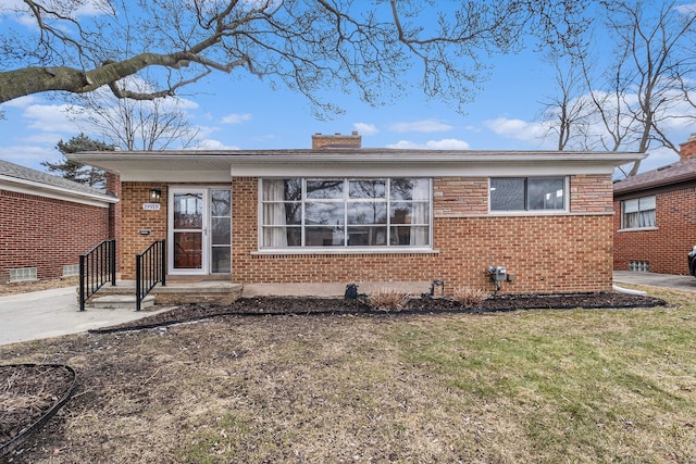 view of front of home with a front yard and brick siding