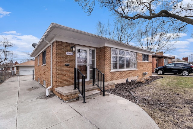 view of front of home featuring entry steps, fence, an outbuilding, and brick siding