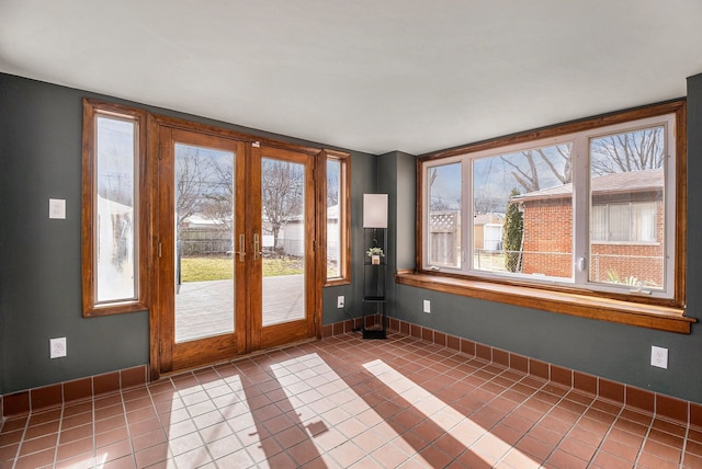 empty room with tile patterned flooring, baseboards, and french doors