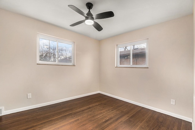 spare room featuring ceiling fan, baseboards, and dark wood finished floors