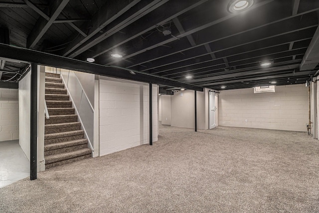 finished basement with stairway and carpet flooring