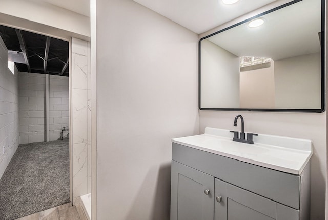 bathroom featuring walk in shower, vanity, and recessed lighting