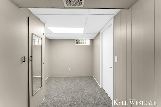 basement with carpet floors, a paneled ceiling, visible vents, and baseboards