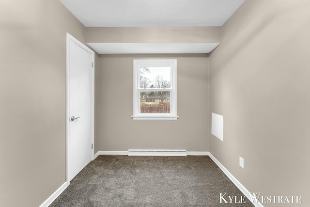 carpeted empty room featuring a baseboard heating unit and baseboards