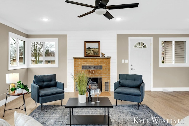 living area with recessed lighting, a brick fireplace, wood finished floors, and baseboards