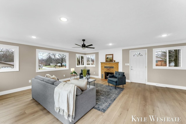 living area with recessed lighting, a brick fireplace, baseboards, and wood finished floors