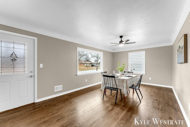 dining room with ceiling fan, baseboards, visible vents, and dark wood finished floors