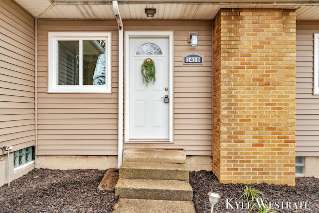 doorway to property featuring brick siding