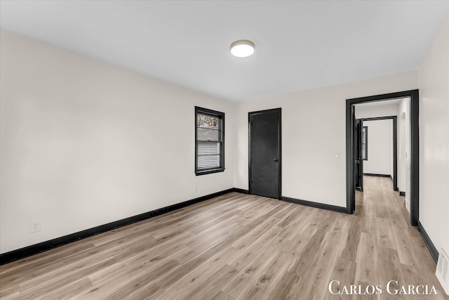 unfurnished bedroom featuring visible vents, light wood finished floors, and baseboards