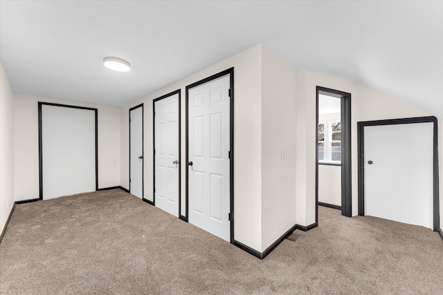 unfurnished bedroom featuring carpet flooring, two closets, and baseboards