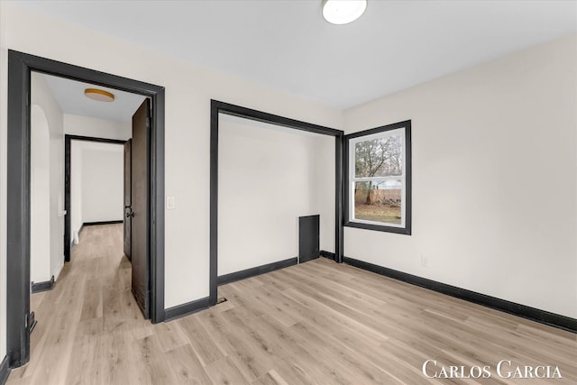 interior space featuring light wood-type flooring and baseboards