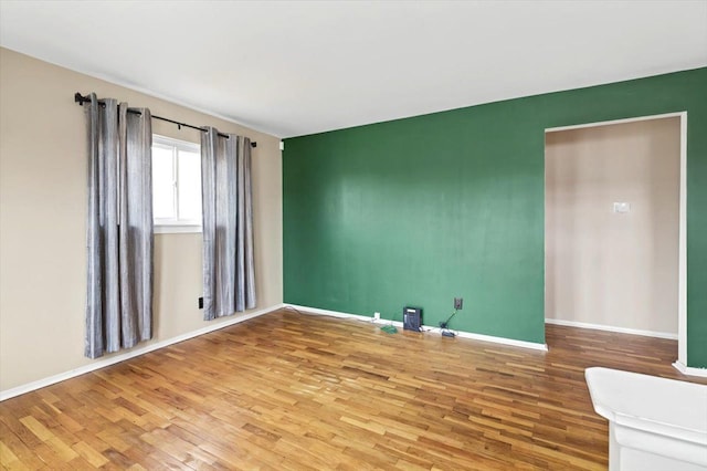 unfurnished room featuring wood finished floors and baseboards