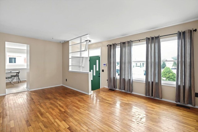 empty room featuring light wood finished floors and baseboards