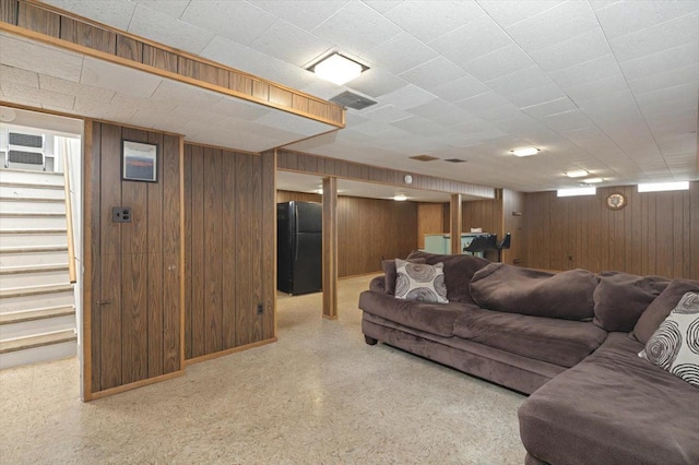 living area featuring wooden walls and baseboards