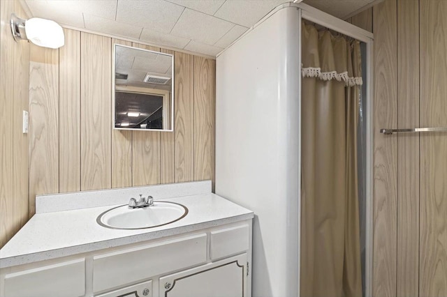 bathroom with wooden walls and vanity