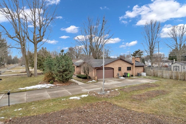 exterior space featuring a chimney, concrete driveway, a lawn, an attached garage, and fence