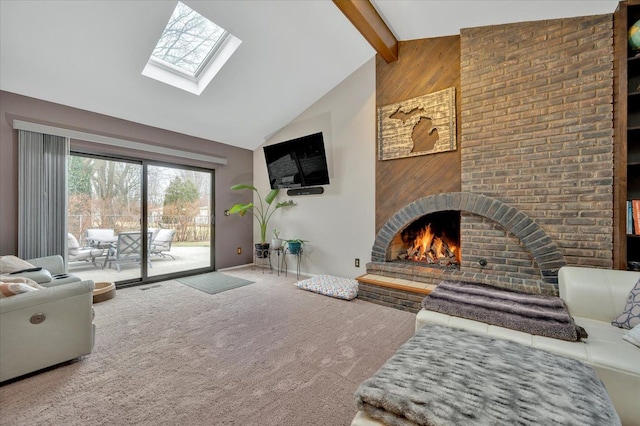 carpeted living room with high vaulted ceiling, a skylight, a fireplace, and beamed ceiling