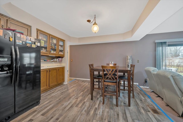 dining area featuring light wood-type flooring and baseboards