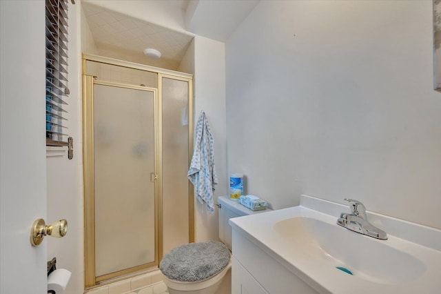 bathroom featuring vanity, a shower stall, and toilet