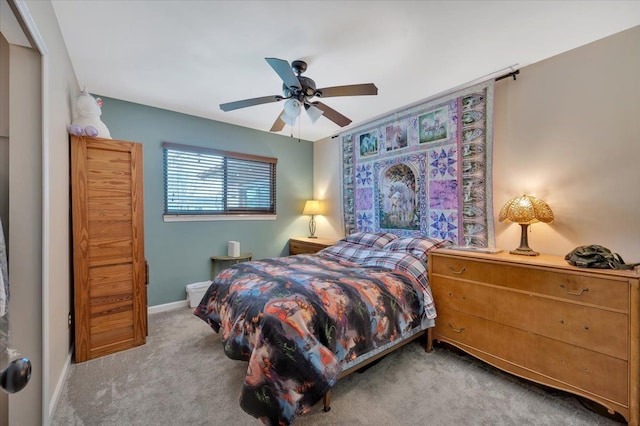 carpeted bedroom with ceiling fan and baseboards