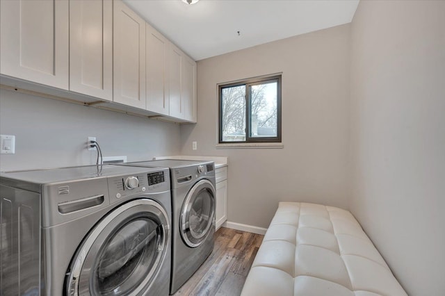 clothes washing area with cabinet space, light wood-style flooring, baseboards, and independent washer and dryer