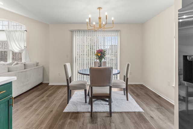 dining room with baseboards, an inviting chandelier, and wood finished floors