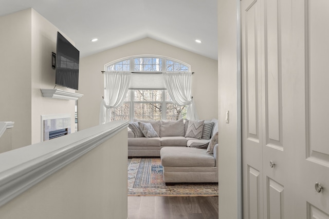 living room featuring recessed lighting, a fireplace, lofted ceiling, and wood finished floors