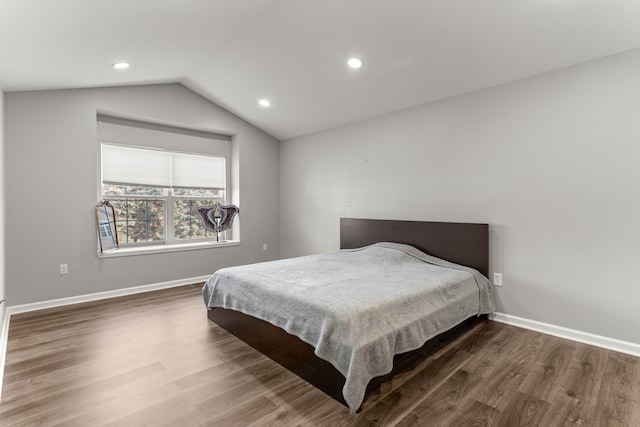 bedroom featuring vaulted ceiling, wood finished floors, and baseboards