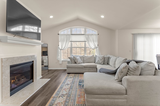 living room featuring dark wood finished floors, lofted ceiling, recessed lighting, and a premium fireplace