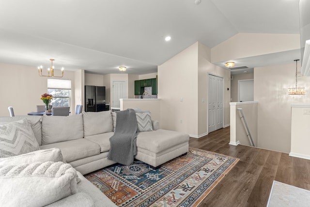 living area with a notable chandelier, dark wood-type flooring, baseboards, and vaulted ceiling