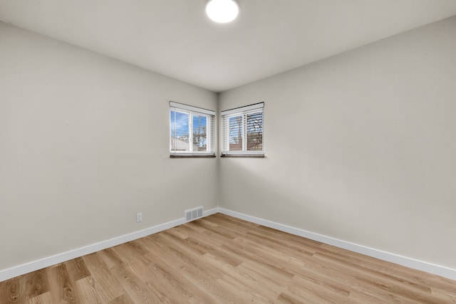 empty room featuring baseboards, visible vents, and light wood-type flooring