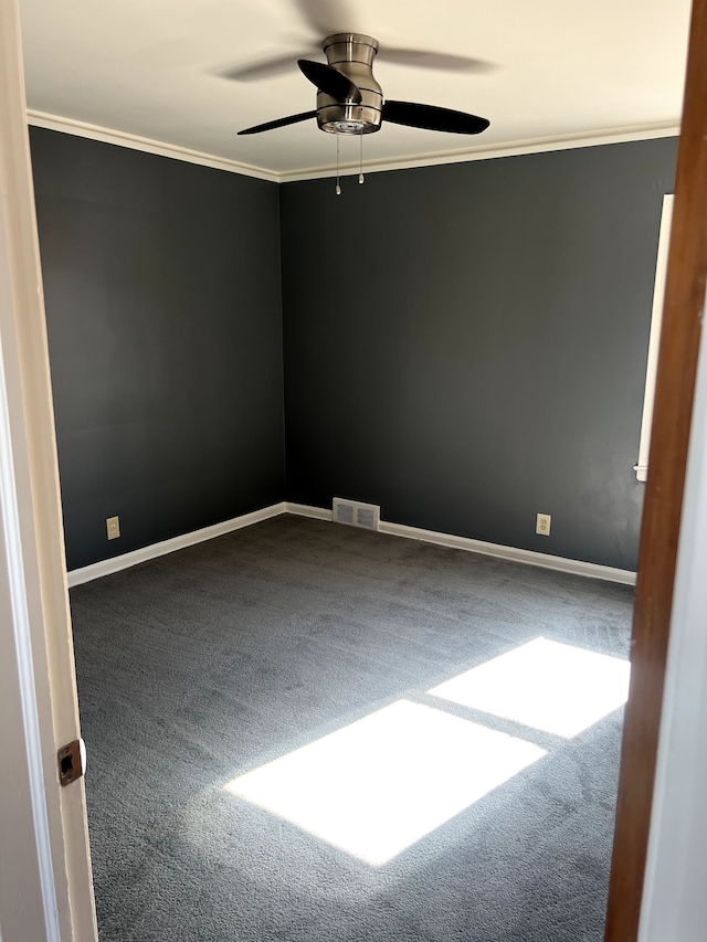 empty room featuring visible vents, baseboards, carpet, and crown molding