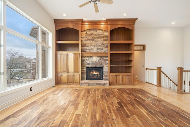 unfurnished living room with recessed lighting, baseboards, a fireplace, and light wood finished floors